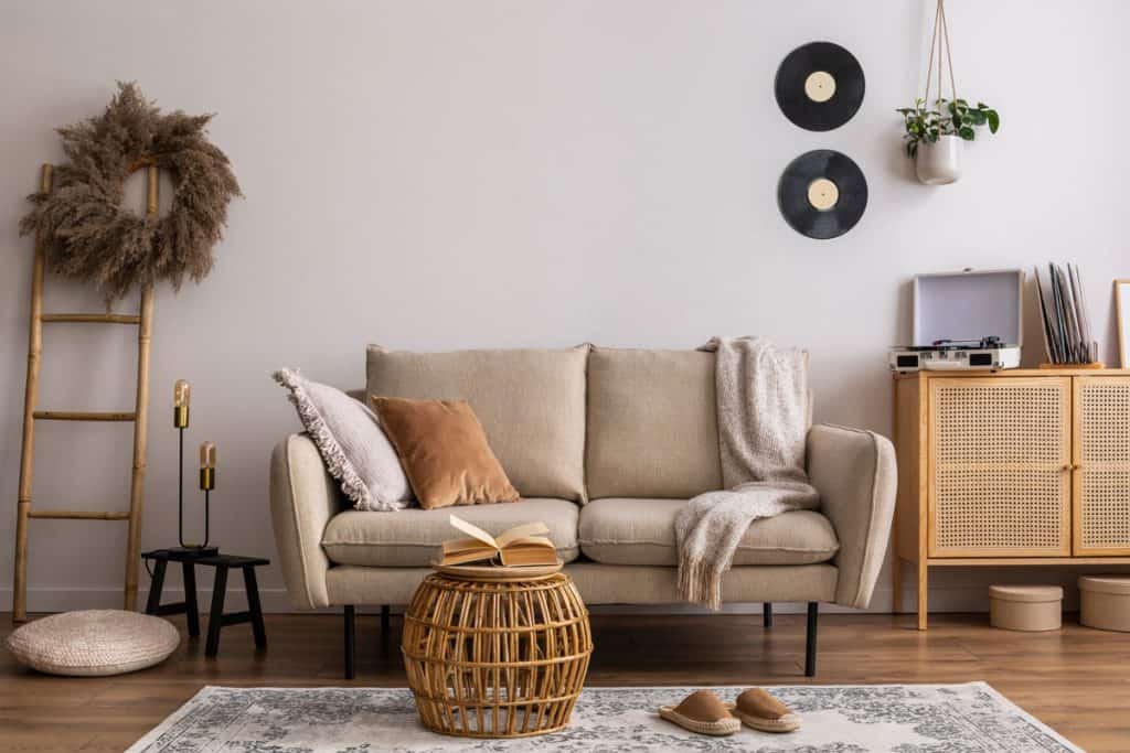 Beige wall with a matching beige sofa and boho themed furnitures