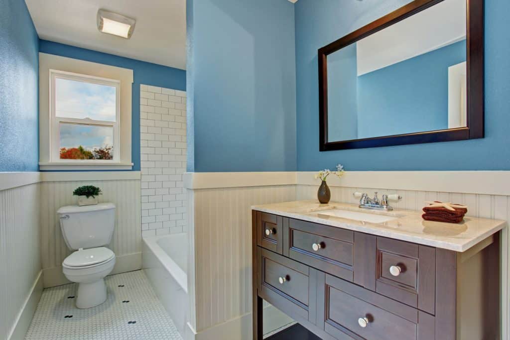 Blue and white themed bathroom with a brown vanity