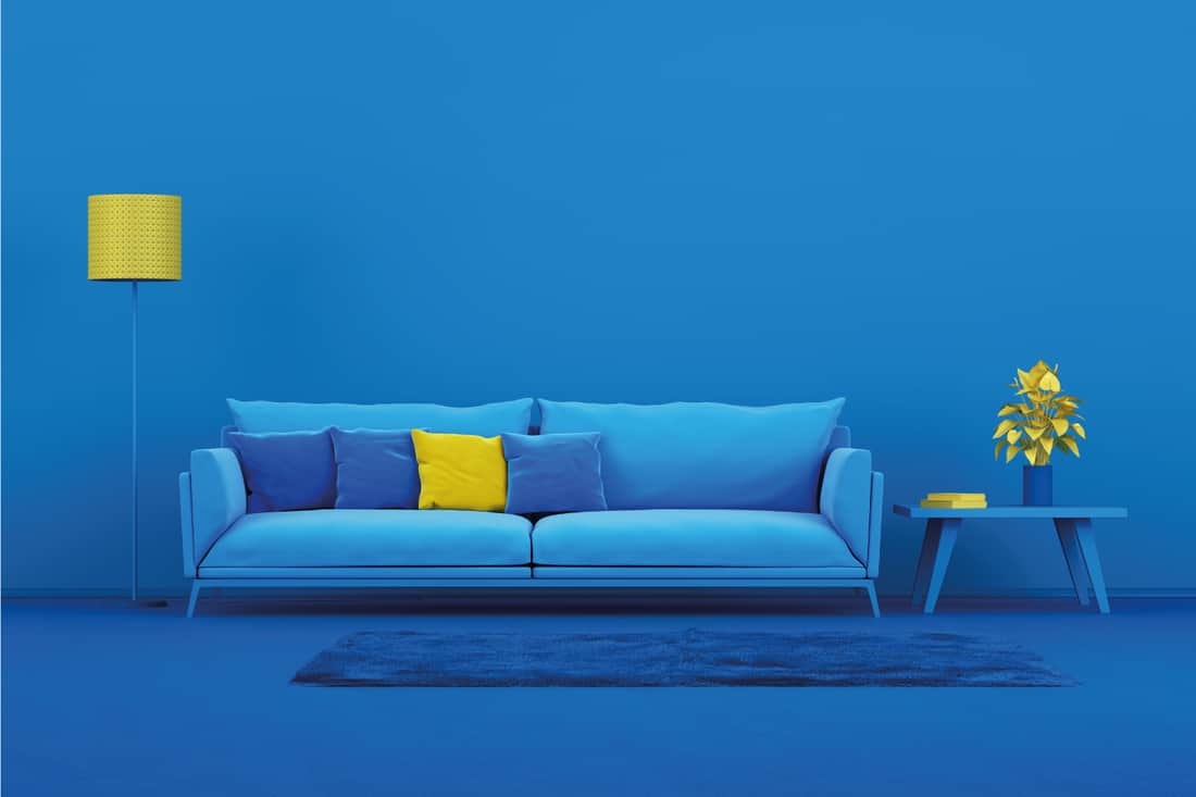 Blue modern sofa in blue living room with yellow pillow and standing lamp
