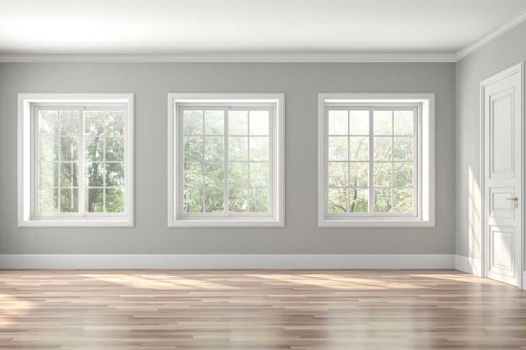 Classical empty room interior with wooden floors, gray walls and decorated with white moulding, What Color Trim Goes With Gray Walls?