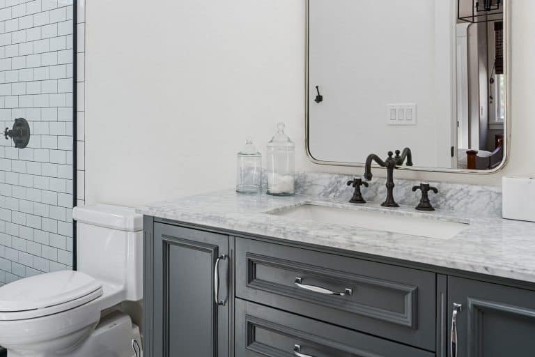 Contemporary designed bathroom with a Victorian styled faucet on a white marble, Should Bathroom Faucets Match Cabinet Fixtures And Hardware?