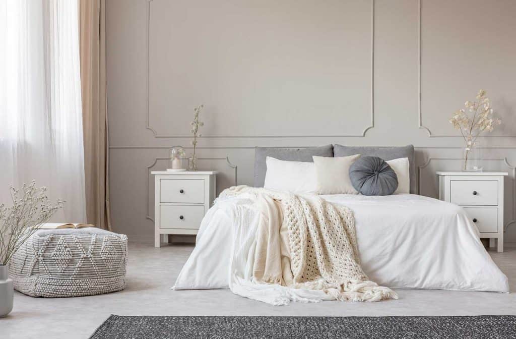 Cozy cream colored woolen blanket on king size bed in bright bedroom