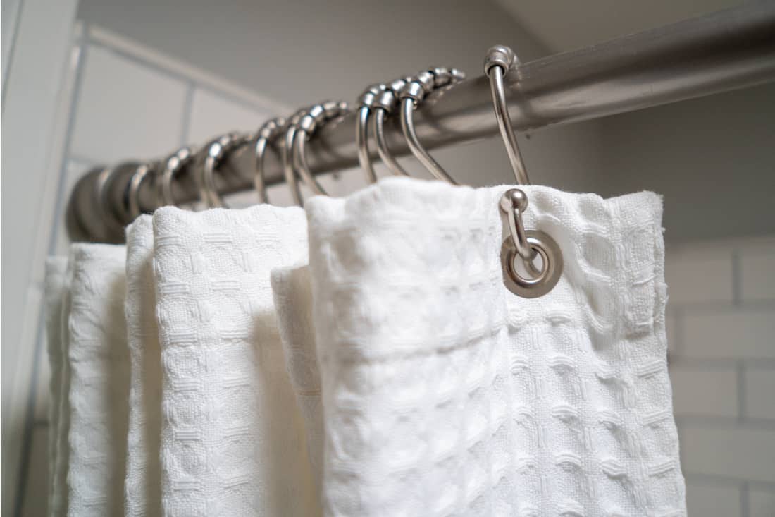 Decorative luxurious white shower curtain on metal hooks, How High Do You Hang A Shower Curtain?