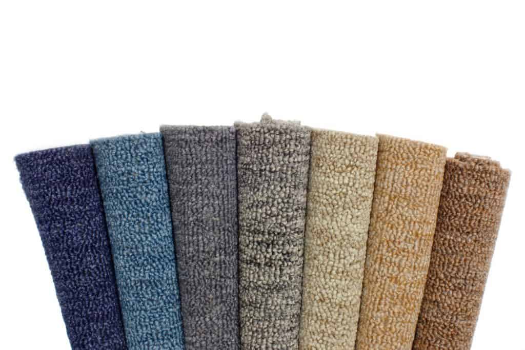 Different colored rolled carpets isolated on a white background