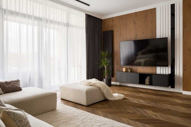 Elegant designed living room with window wall, big television screen and wooden elements, What Color Carpet Goes With Brown Walls?