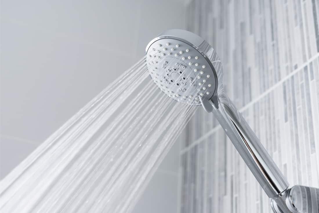 Water running from shower head in modern bathroom