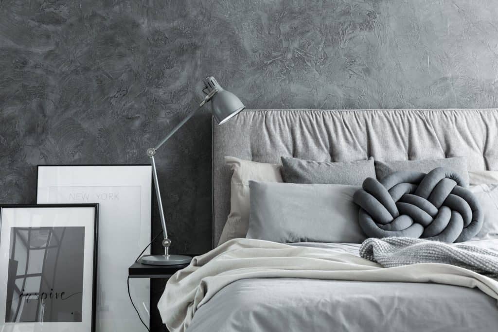 Gray and cream themed bedroom with light gray beddings and a study lamp on the side