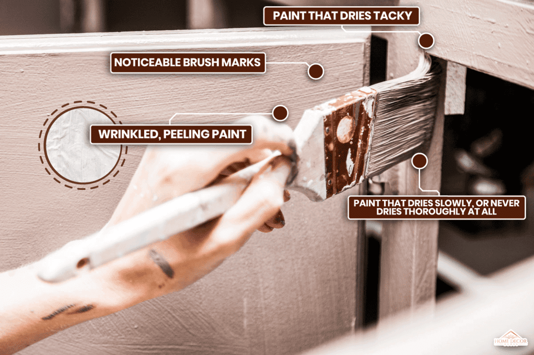 Person Holding Paint Brush and Painting Kitchen Cabinets