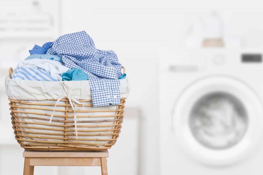Laundry basket on blurred background of modern washing machine 