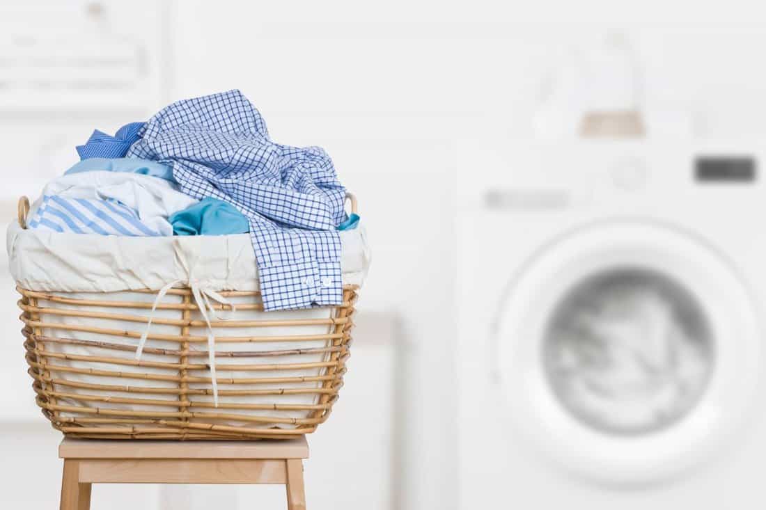Laundry basket on blurred background of modern washing machine