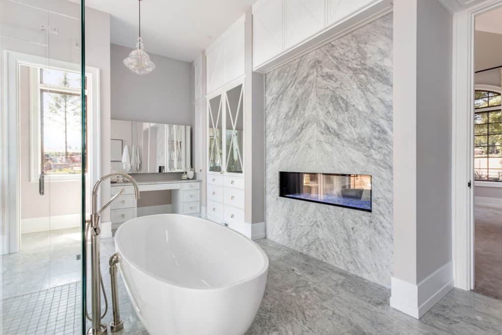 Luxurious bathroom area with a light gray painted wall and a white bathtub