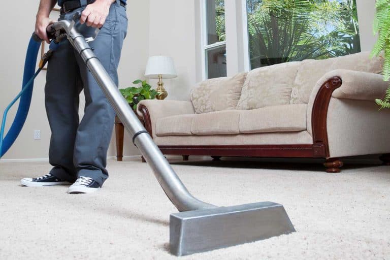 Man cleaning carpet in home with vacuum cleaner, How To Use A Bissell ProHeat Carpet Cleaner And Shampooer
