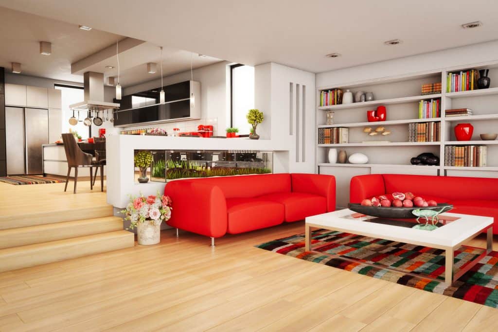 Modern living room with a two level room with red couches and a multi-colored rug with a white table