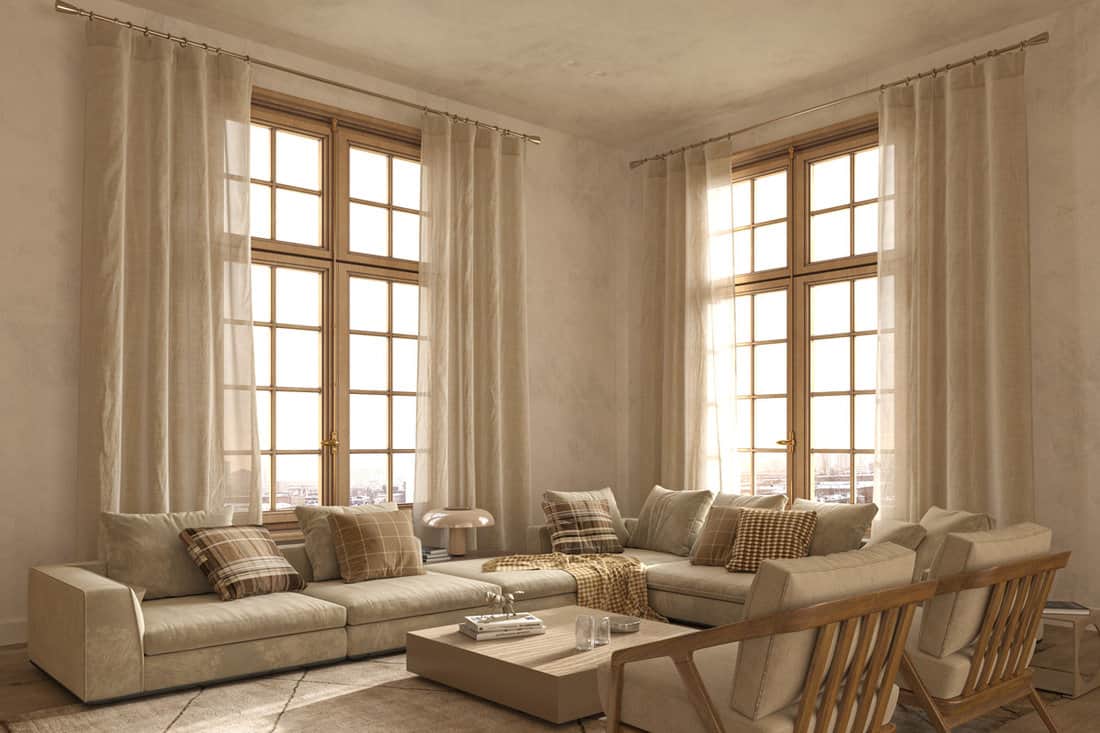 Rustic inspired living room with ceiling high curtains and matching beige sectional sofa