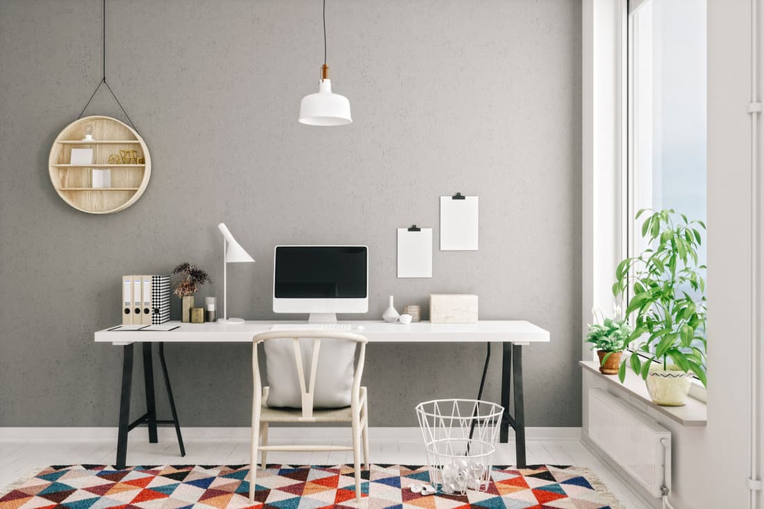 Scandinavian styled home office with a Mac computer on the table and colored rug on the table, How Deep Should A Desk Be?
