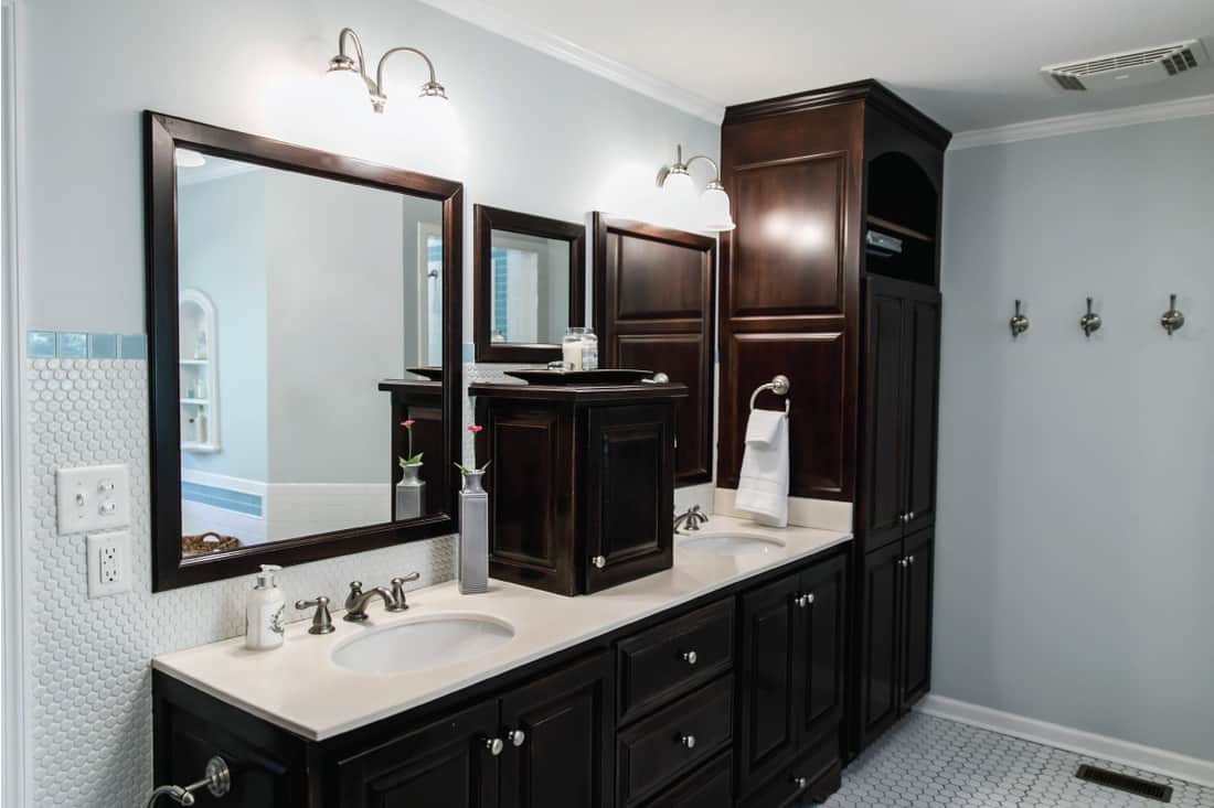 Salle de bain rétro vintage spacieuse qui a besoin d'une mise à jour avec des armoires en bois teinté foncé et un évier et une vanité, comment retenir les armoires de salle de bain [5 Steps]