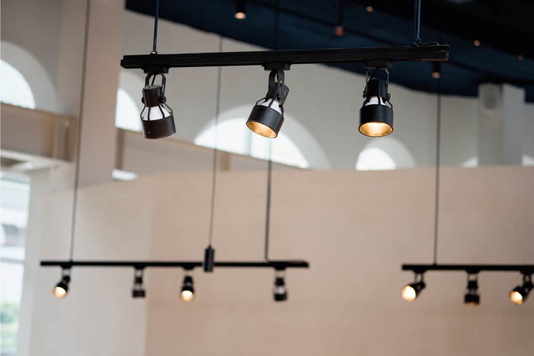 Focos de luzes de pista sob o teto na parede decoração no café