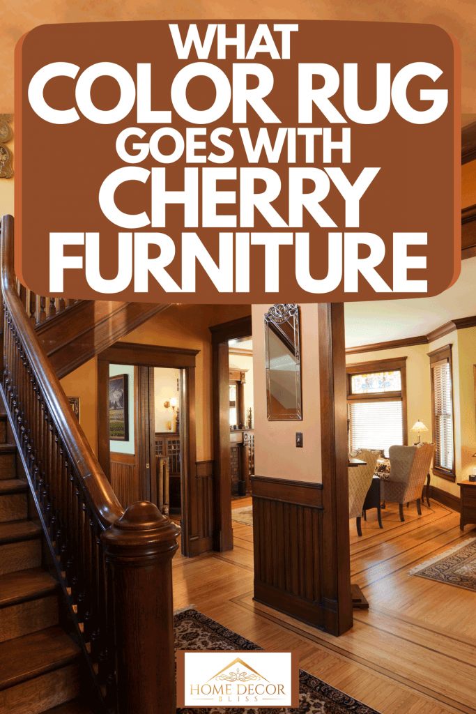 A rustic inspired foyer with wooden stairs and banisters, and hard wood flooring, What Color Rug Goes With Cherry Furniture