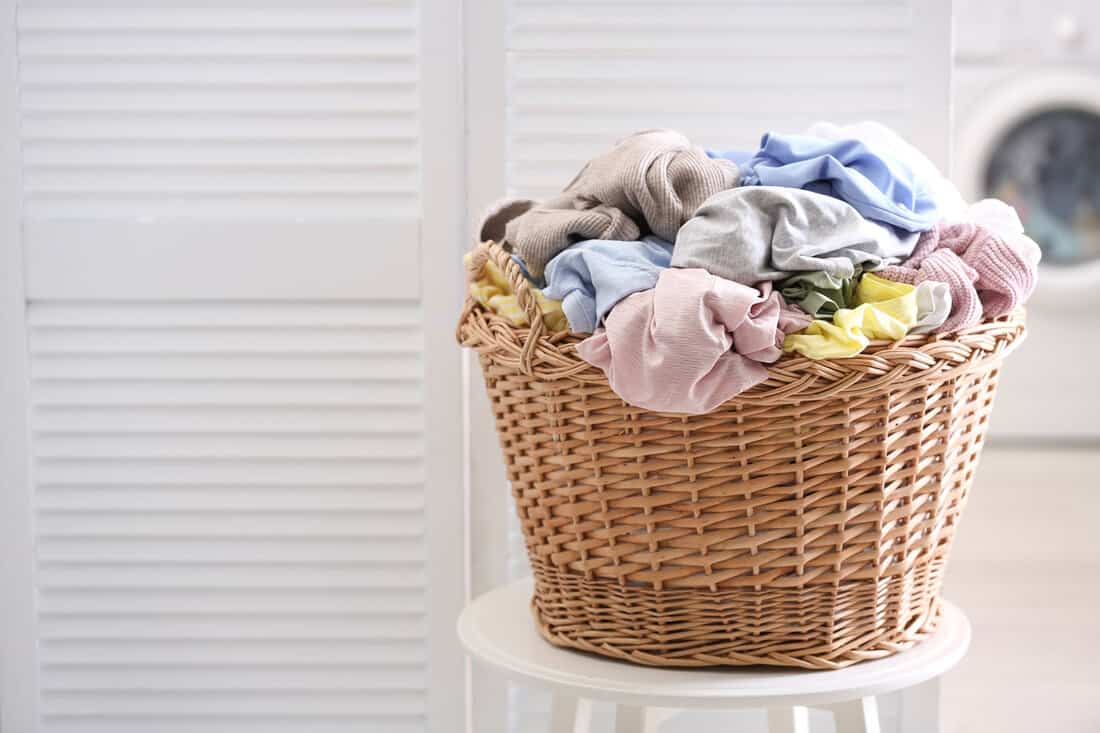 Wicker basket with dirty laundry indoors