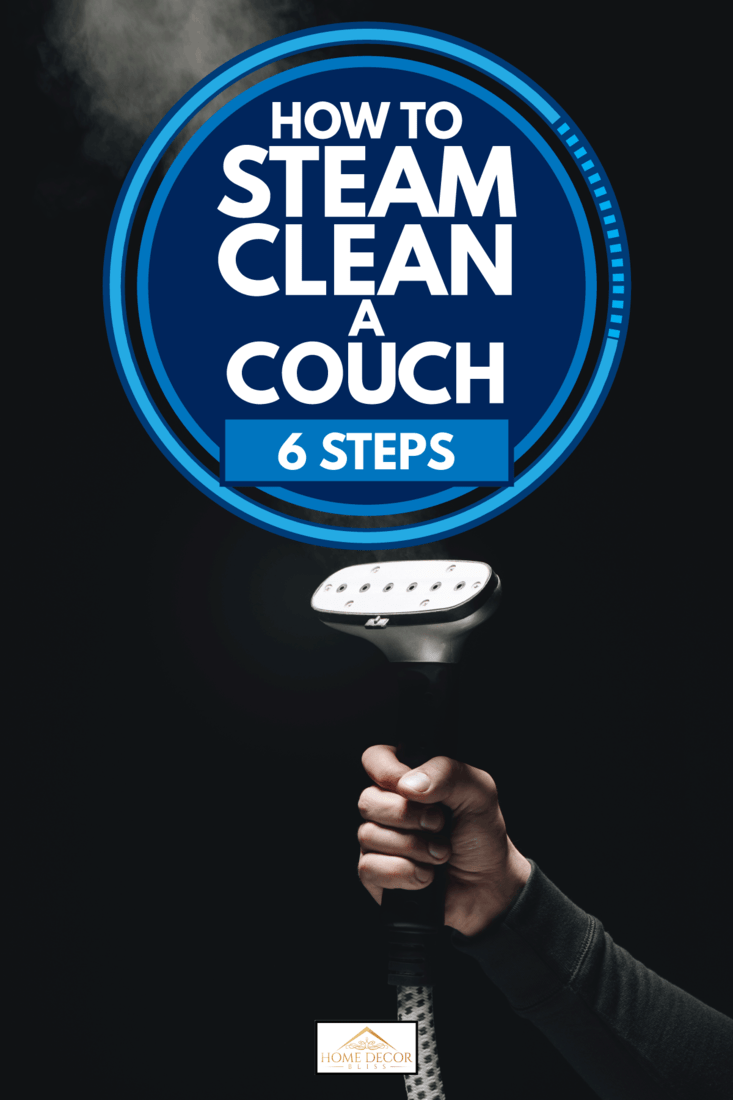 Close-up partial view of person holding garment steamer with steam on black background, How To Steam Clean A Couch (6 Steps)