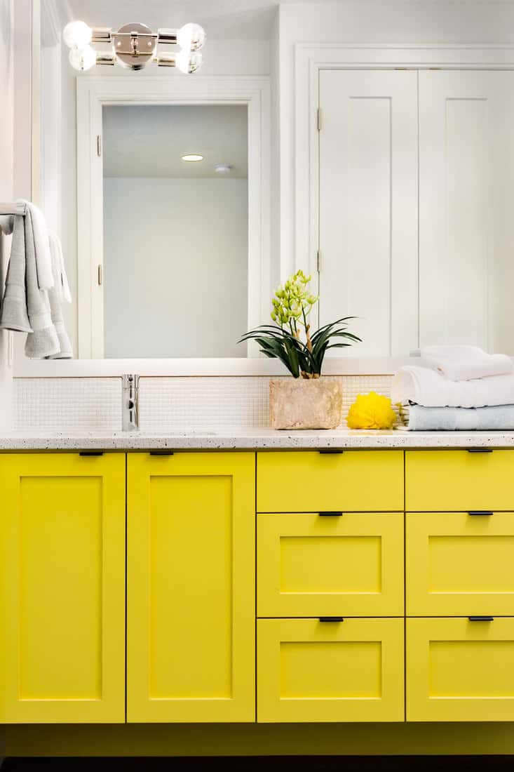 detail closeup of sink, faucet, countertop,yellow cabinets, and mirror, How to Paint Bathroom Cabinets [9 Steps]