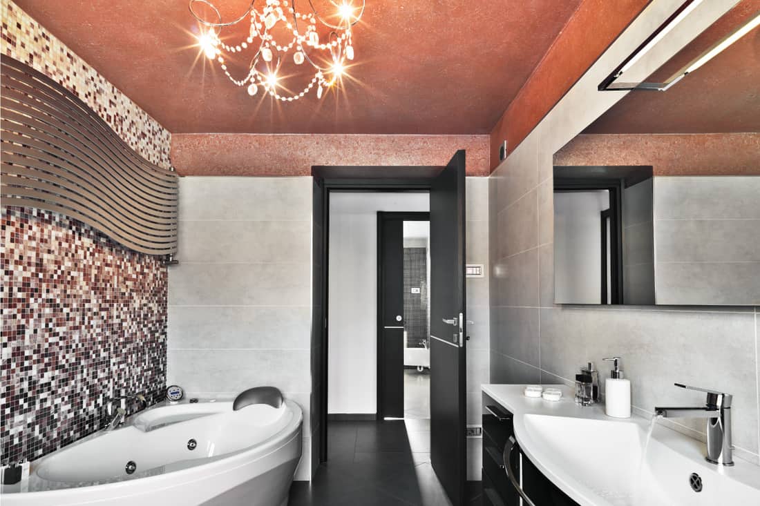 Salle de bain moderne avec baignoire et lavabo, robinet et poignée de porte assortis