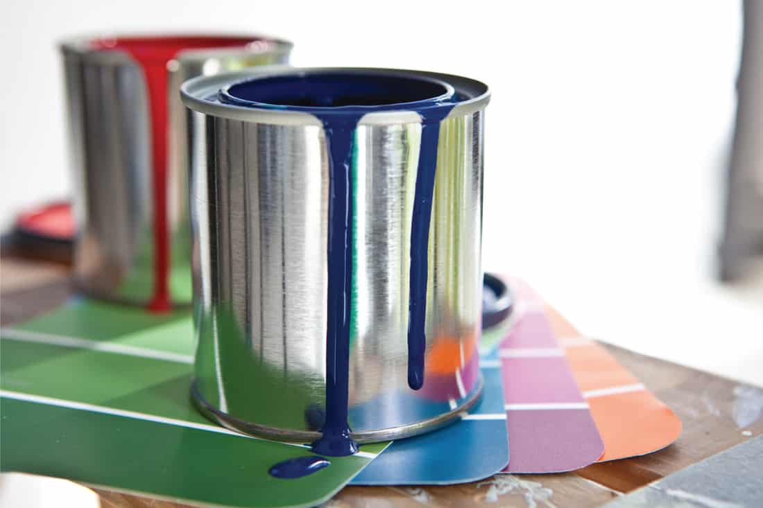 Paint cans and color swatch samples on a table