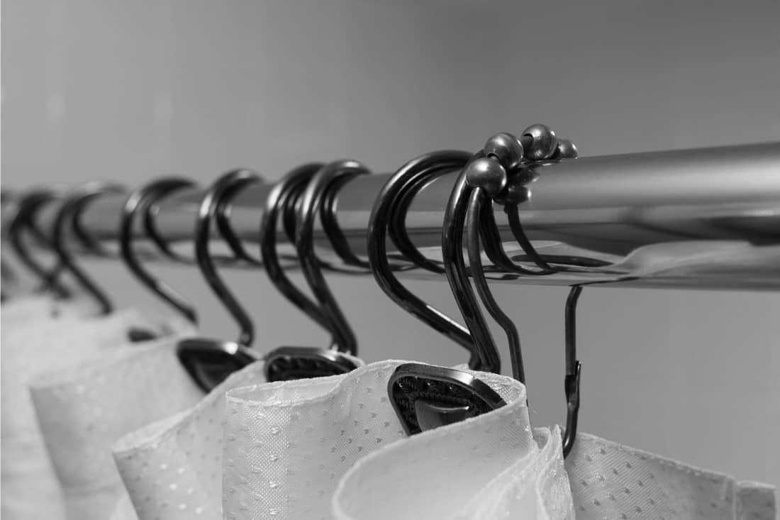 A shower curtain, curtain rod and hooks in black and white