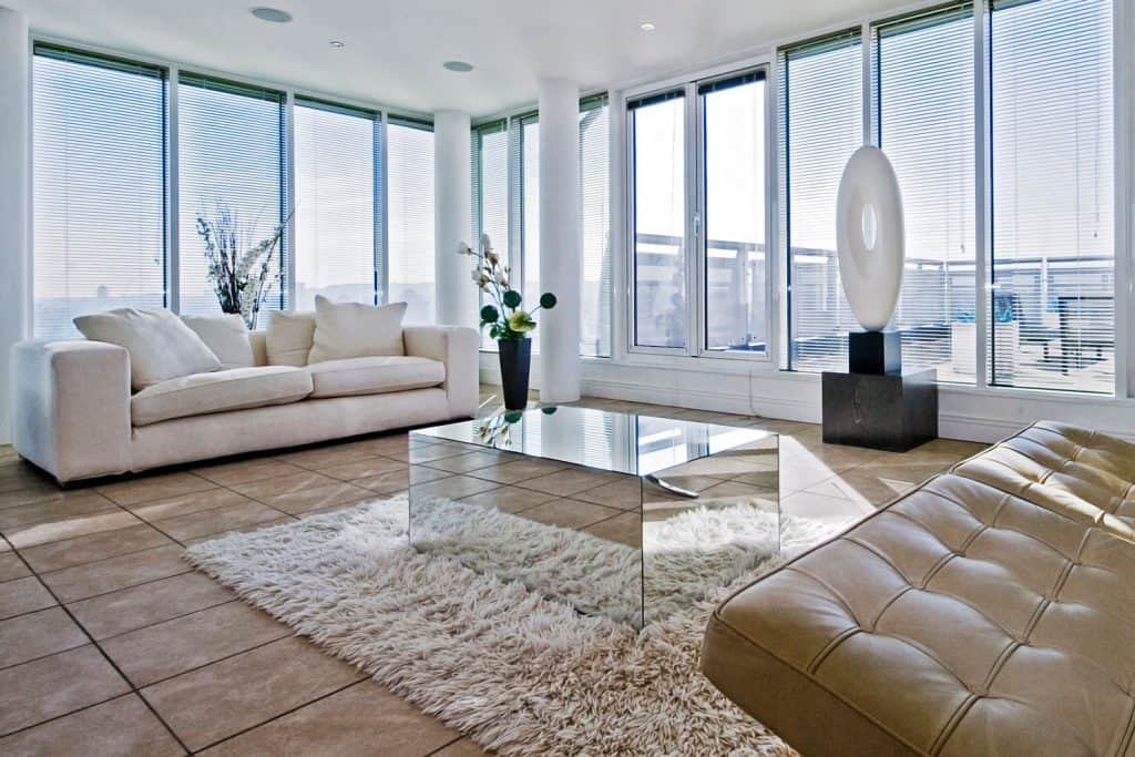 A spacious apartment living room with huge windows and a white sleeper sofa