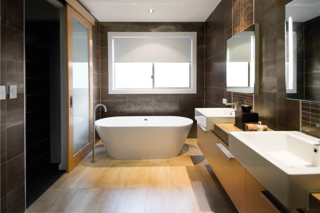 Australian luxury bathroom with brown tile hardwood floor and free standing bath