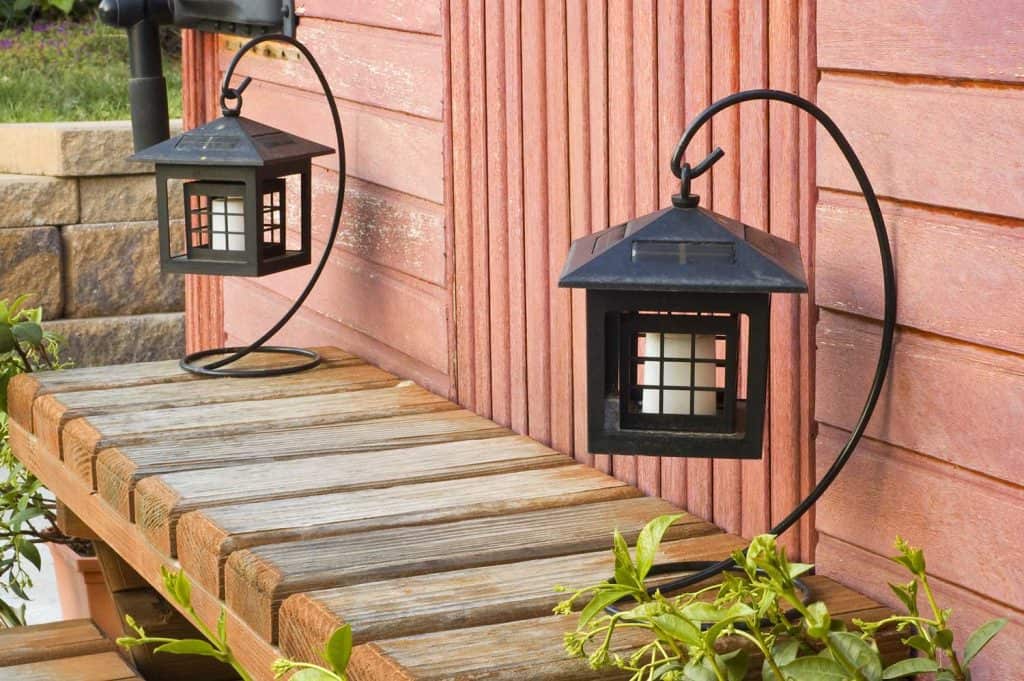 Lanternes noires avec des bougies sur une marche en bois