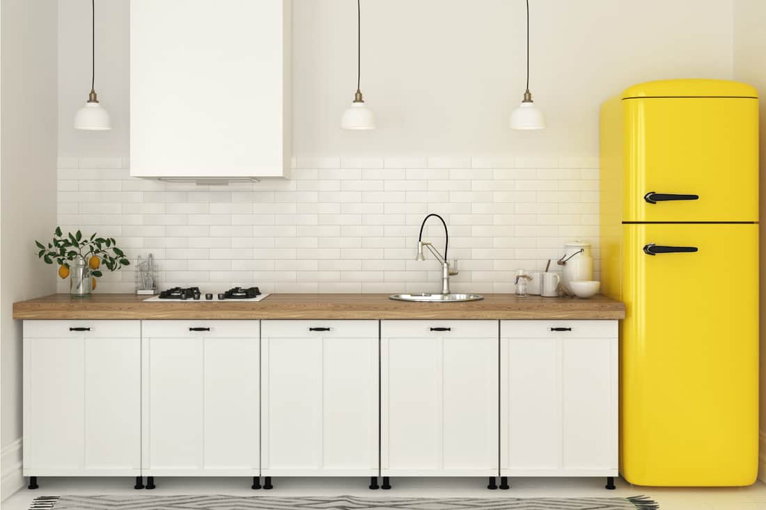 Cuisine lumineuse avec des meubles blancs et un réfrigérateur jaune vif