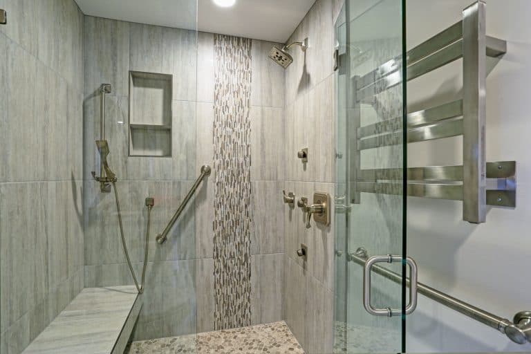 Contemporary bathroom design boasts gorgeous walk-in shower with tiled recessed shelves, built-in bench and accented with glass mosaic tiled vertical stripe, How to Add a Bench to an Existing Shower