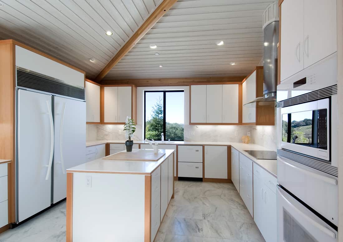 Contemporary white kitchen with wood elements and white countertops