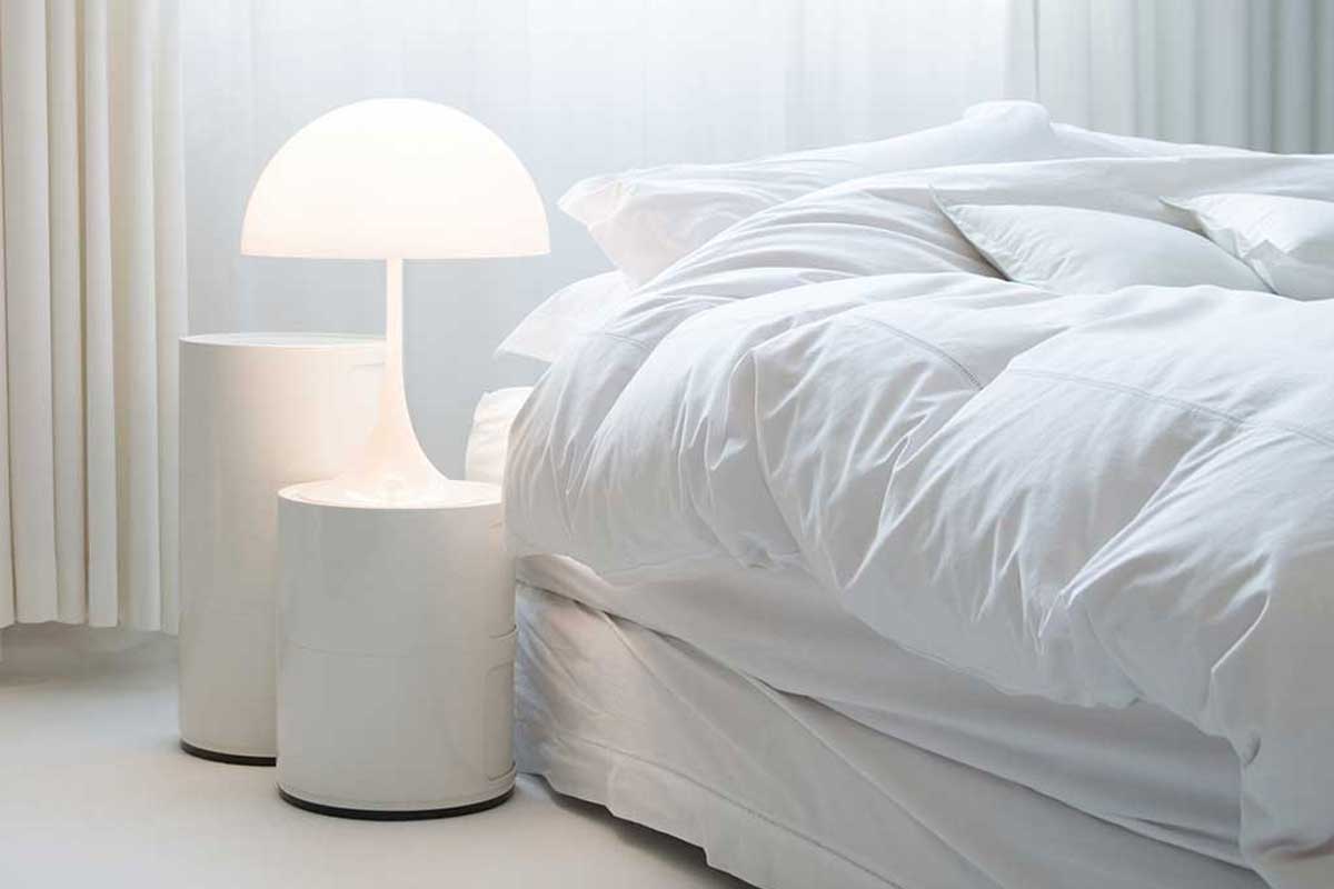 Cozy bed in a white bedroom interior with nightstand, 11 Great Bedroom Nightstands Ideas