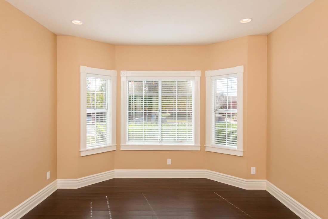 Cream painted walls and a bay window of a empty living room, 14 Types Of Living Room Windows You Should Know