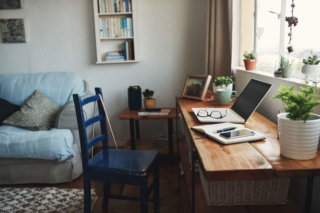 Photo recadrée de la technologie et d'un ordinateur portable sur un bureau dans un bureau à domicile vide pendant la journée