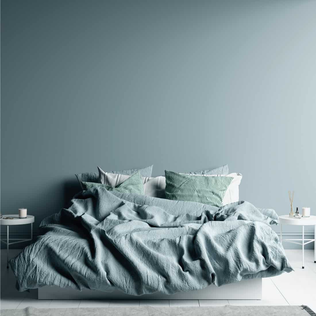 Dark cold blue bedroom interior with linen sheet on bed
