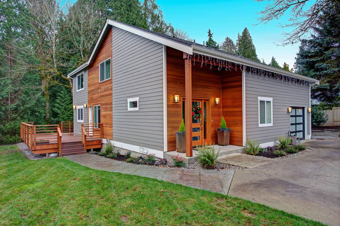 Exterior of a modern rustic home with gray and wooden vinyl sidings