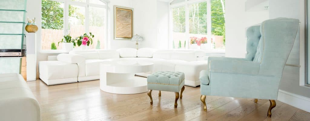 Intérieur magnifique d'une maison de repos tropicale constituée de canapés blancs, de chaises bleues et d'un pouf au centre