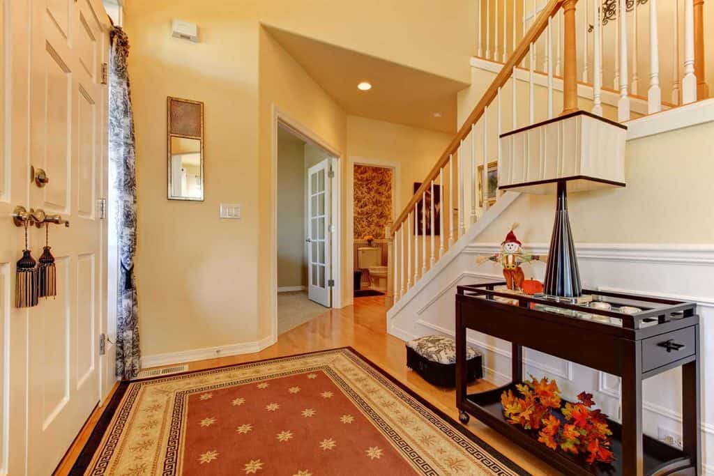 Hallway and entrance with white staircase and warm yellow walls