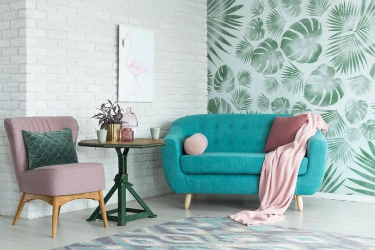 Interior of a blue and pink loveseat with a floral accent wall in the background, Should Pillows On Your Sofa And Loveseat Match?