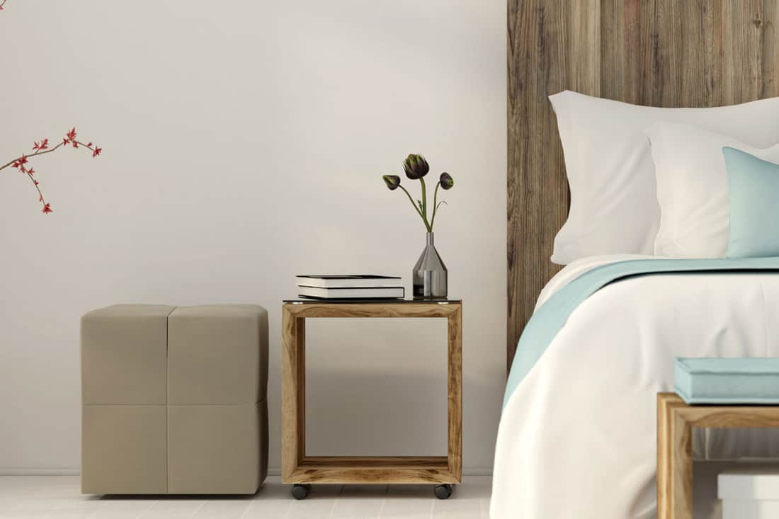 Interior of the bedroom in a minimalist style with bedside table wooden furniture