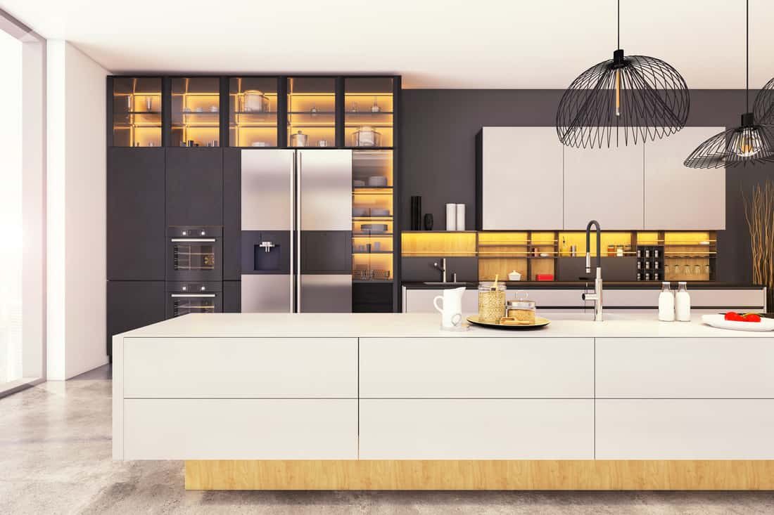 Large modern kitchen interior with kitchen island, pendant lamps, and refrigerator