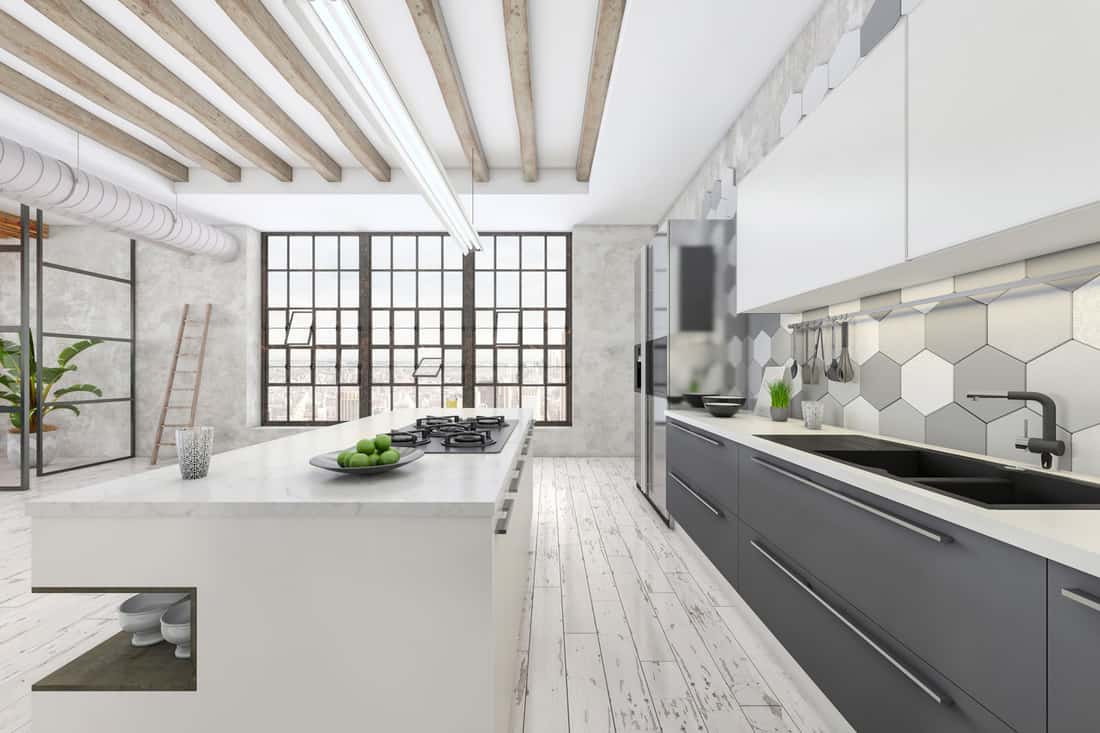 Large modern kitchen interior with white kitchen counter. grey tiled wall, parquet, sink, window and concrete wall in the background