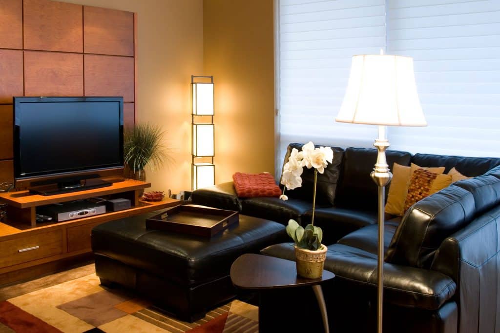 Appartement contemporain luxueux avec des canapés sombres et un large pouf sombre