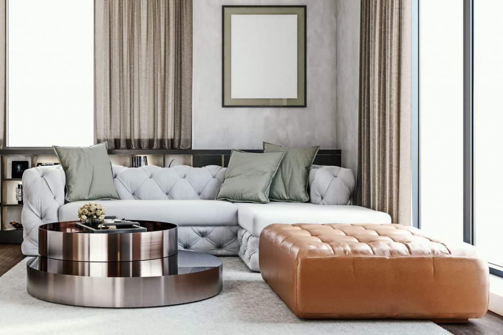 Luxurious retro themed living room with a white sofa, brown ottoman, and a round metal coffee table