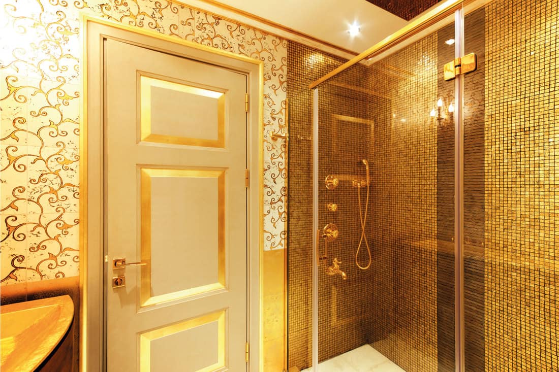 Luxurious gold theme shower room with golden door and wall tiles
