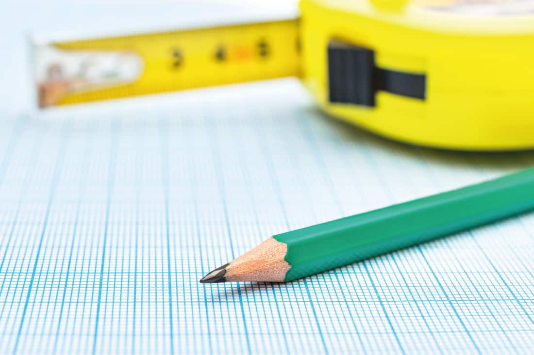 Measuring tape tool with pencil on graph paper
