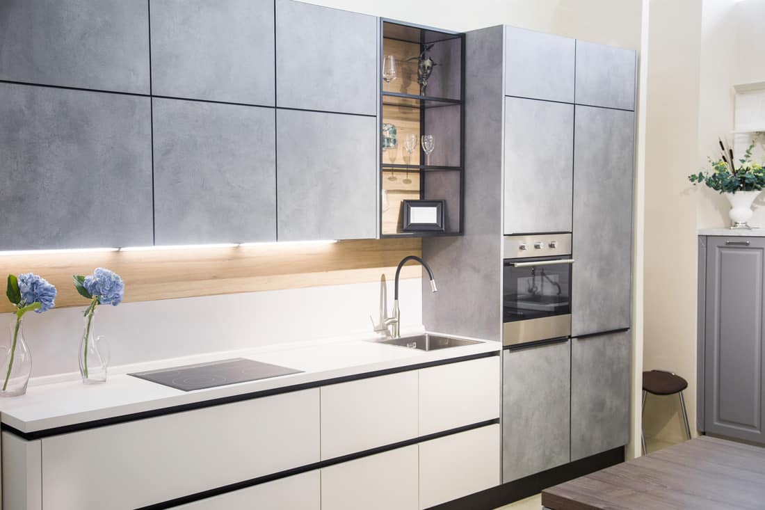 Intérieur de cuisine moderne avec des murs en briques blanches, des comptoirs en bois avec un évier intégré et une cuisinière